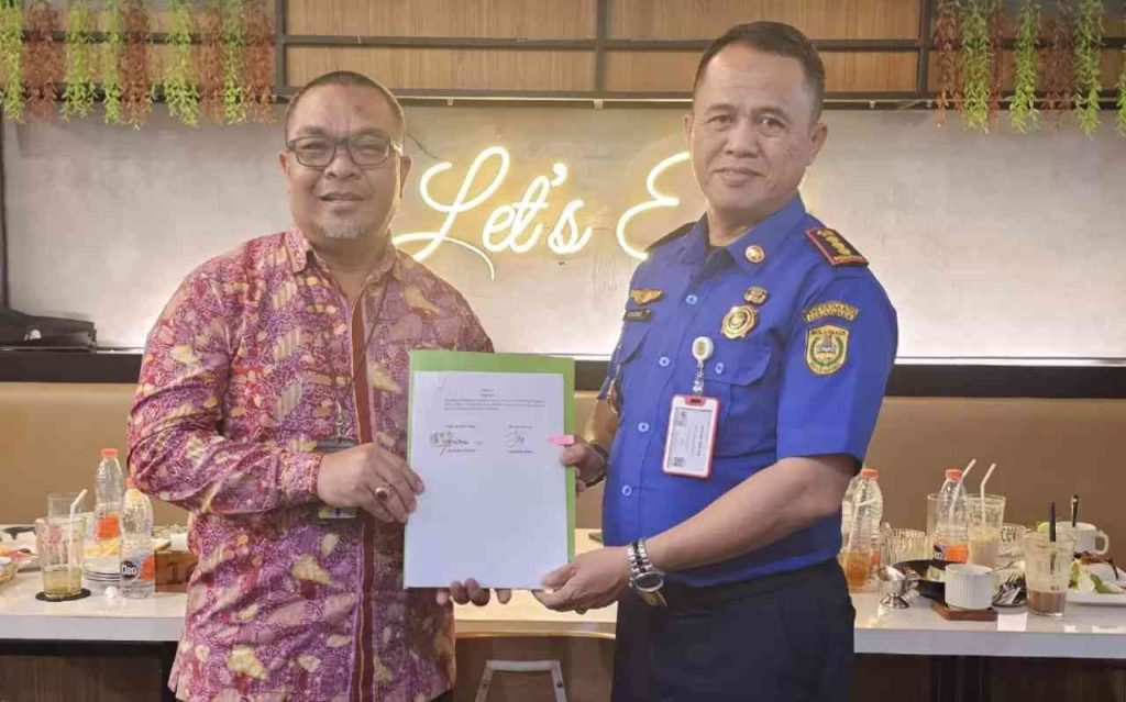 Kepala BPJAMSOSTEK Banjarmasin Sunardy Syahid bersama Kepala Dinas Damkar Banjarmasin Hendro menunjukkan dokumen kerja sama perlindungan sosial untuk relawan pemadam kebakaran.